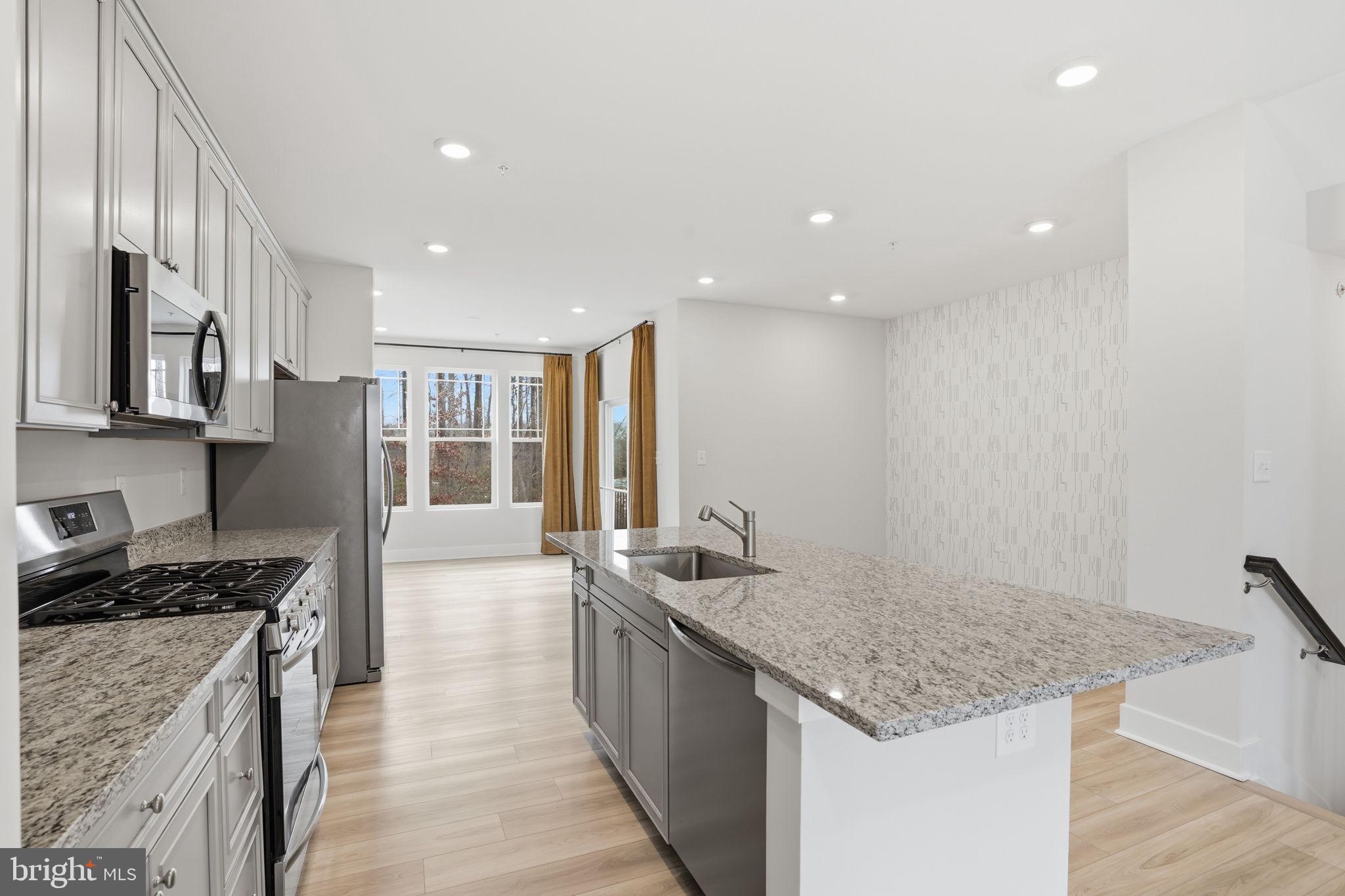 1810 Betterton Road Essex, MD 21221 - Photo 16 of 34 a kitchen with stainless steel appliances granite countertop a sink stove and refrigerator