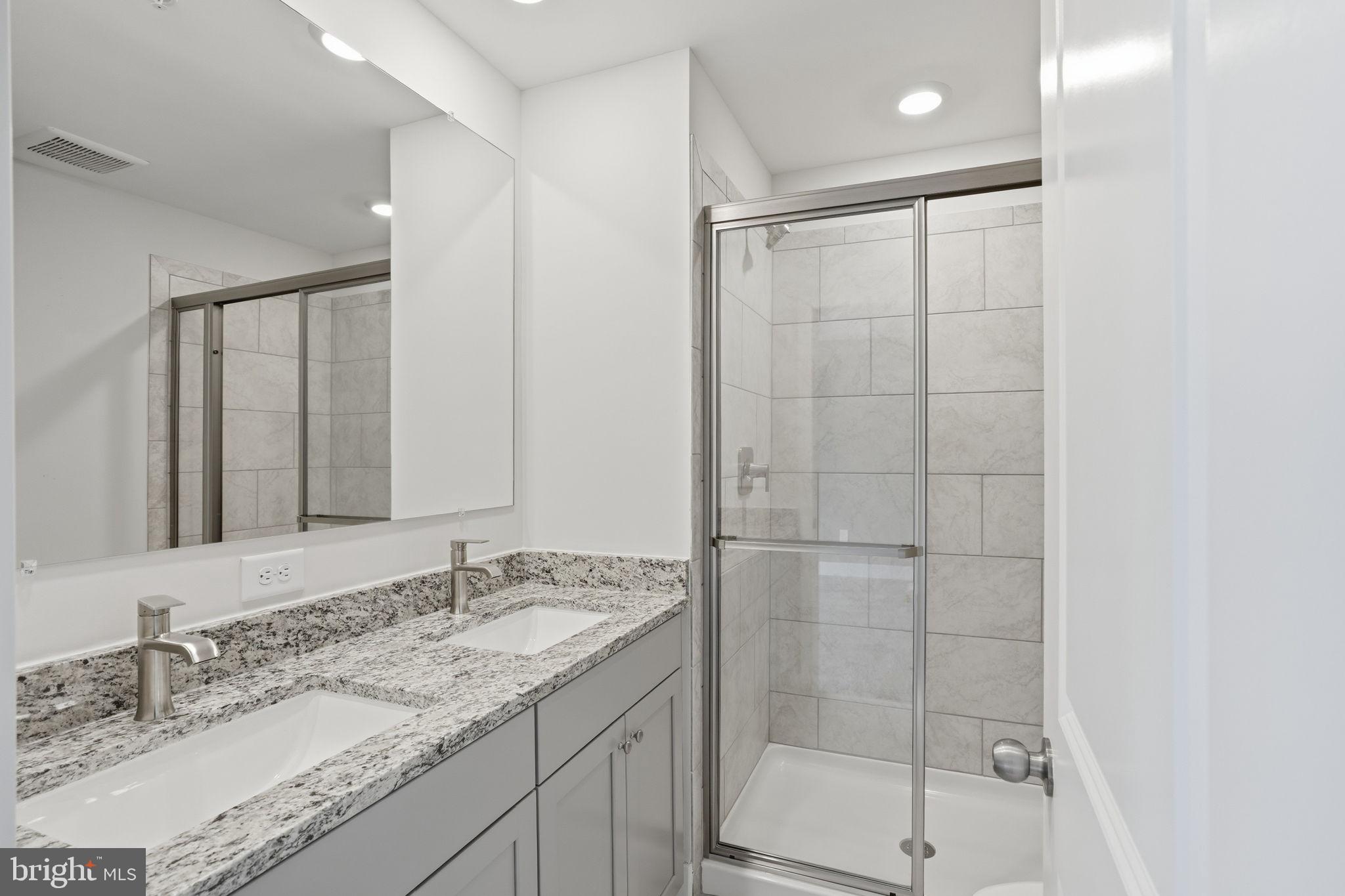 1810 Betterton Road Essex, MD 21221 - Photo 23 of 34 a bathroom with a granite countertop sink a mirror and shower