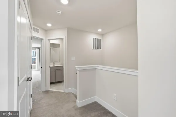 a view of a hallway with closet and bathroom