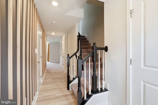 a view of a hallway with wooden floor and staircase