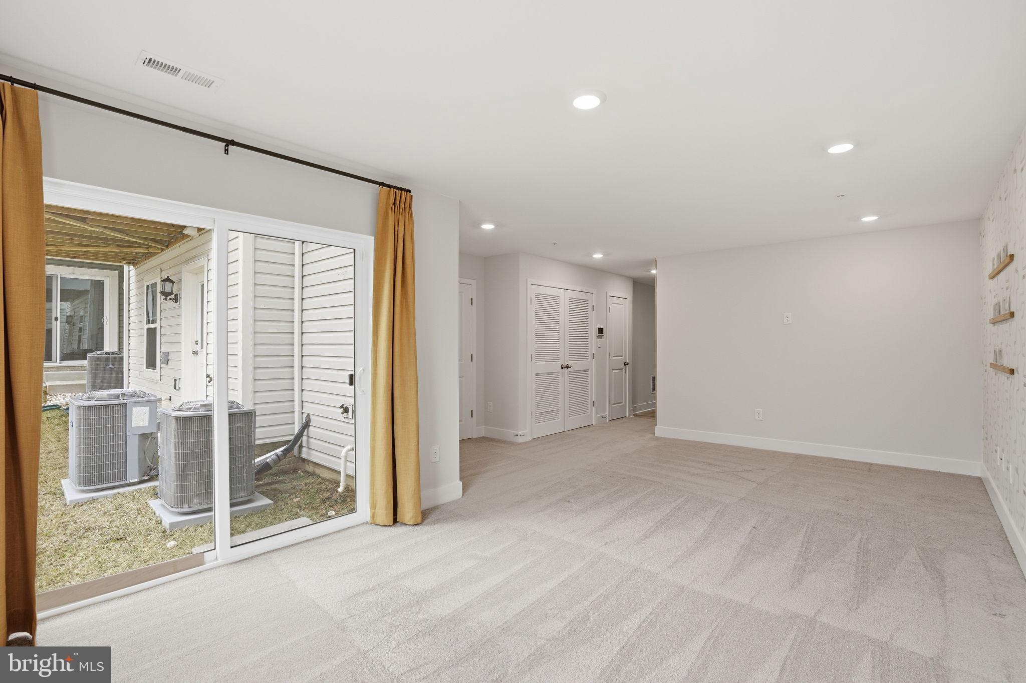 1810 Betterton Road Essex, MD 21221 - Photo 6 of 34 en empty room with sliding glass door and chandelier fan