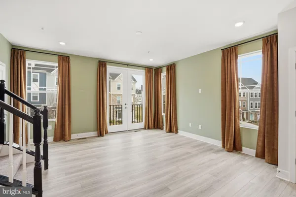 a view of a big room with wooden floor and windows