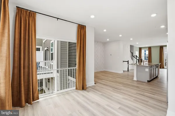 a view of a hallway with wooden floor and livingroom