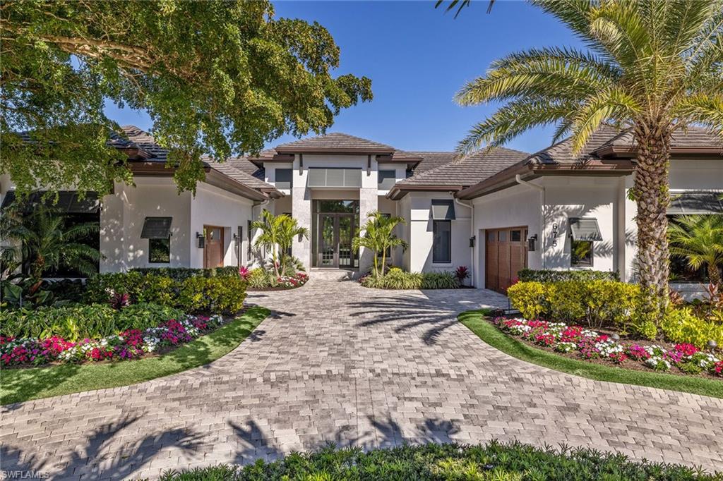 a front view of a house with a garden and fountain