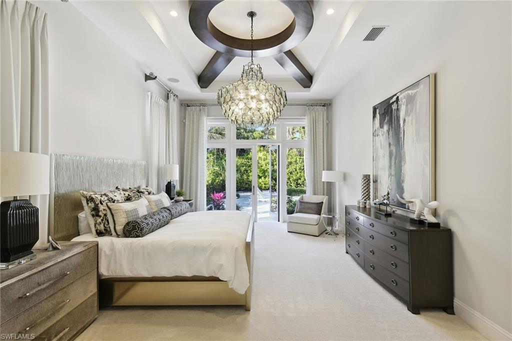 675 Anchor Rode Drive Naples, FL 34103 - Photo 11 of 19 a spacious bedroom with bed and a large mirror