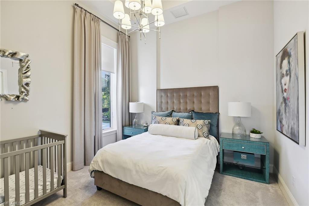 675 Anchor Rode Drive Naples, FL 34103 - Photo 16 of 19 a bedroom with a bed and a chandelier