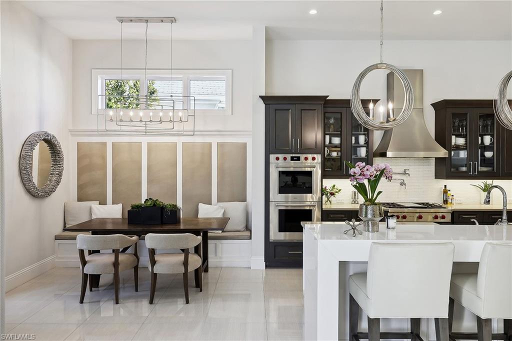 675 Anchor Rode Drive Naples, FL 34103 - Photo 8 of 19 a dining room with wooden floor a chandelier a wooden table and chairs