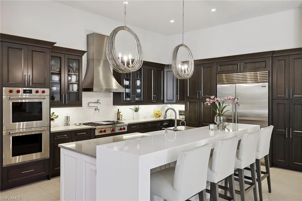 675 Anchor Rode Drive Naples, FL 34103 - Photo 9 of 19 a kitchen with stainless steel appliances a stove a table a sink and cabinets
