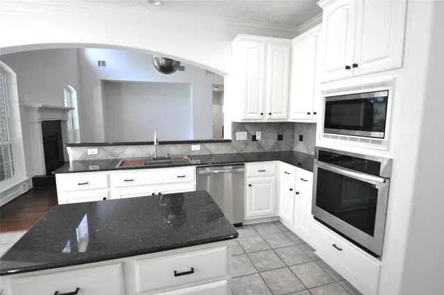 a kitchen with granite countertop white cabinets and white appliances