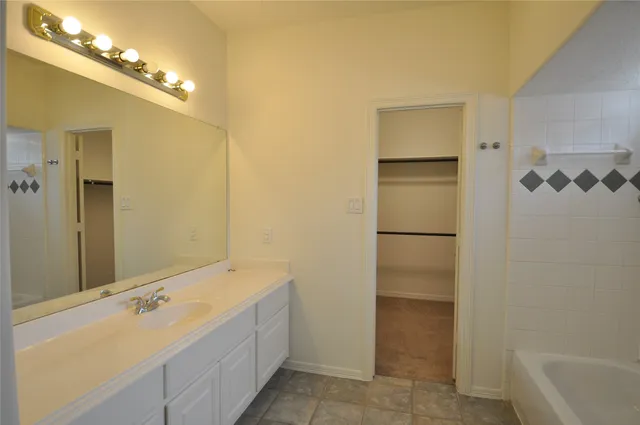 a bathroom with a tub sink and mirror