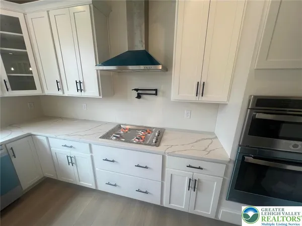 a kitchen with white cabinets and appliances