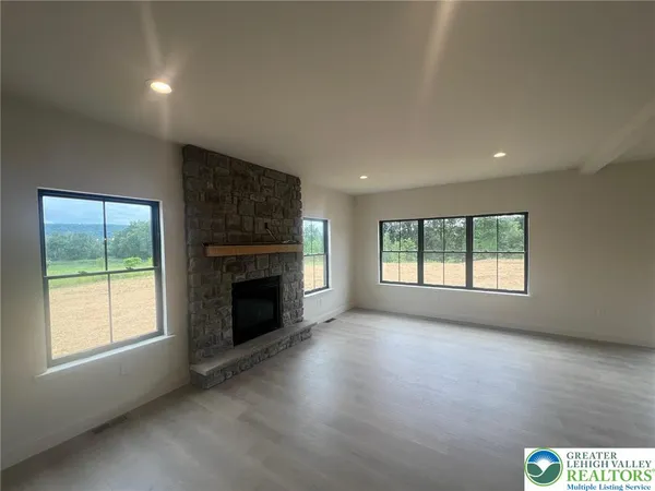 an empty room with windows and fireplace