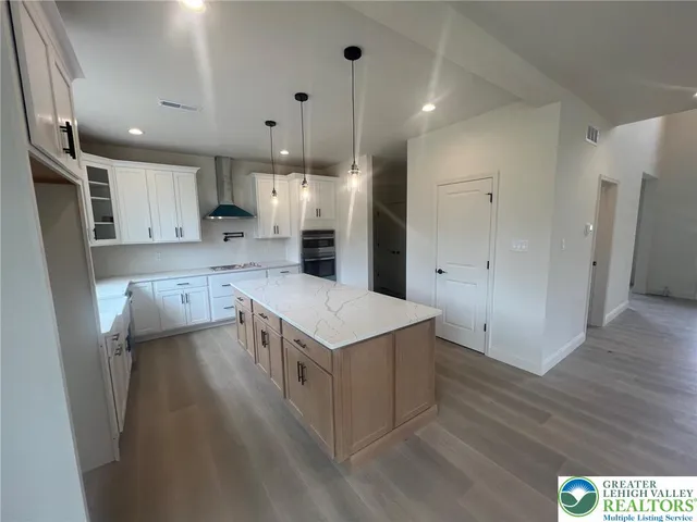 a kitchen with a refrigerator a sink and wooden floor