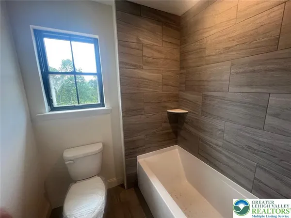 a bathroom with a toilet and bathtub