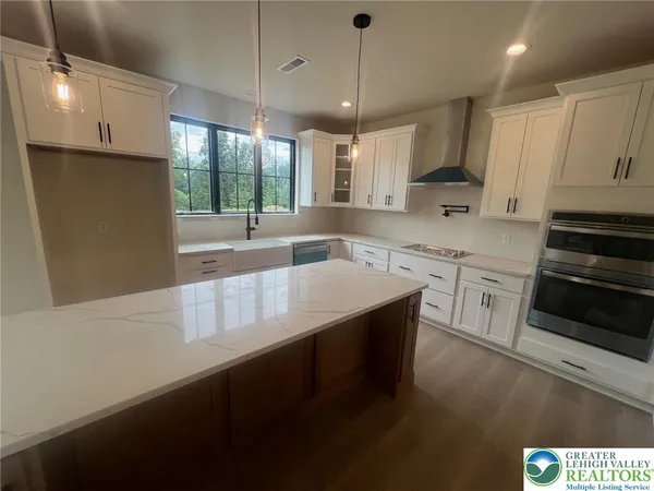 a kitchen with stainless steel appliances granite countertop a sink a stove and a refrigerator