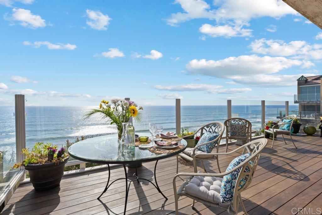 1048 Neptune Avenue Encinitas, CA 92024 - Photo 1 of 54 a roof deck with table and chairs and wooden floor