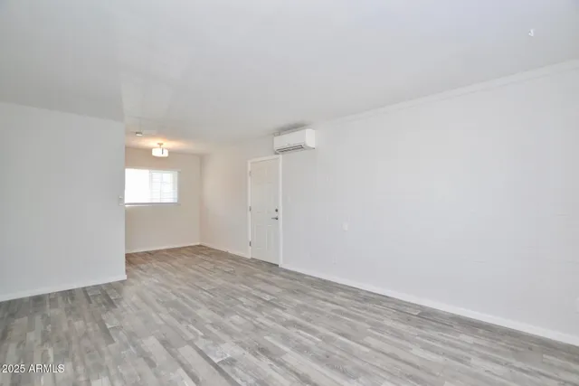 an empty room with wooden floor and window