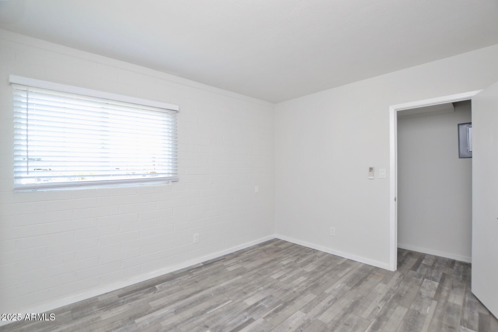 44 East Roanoke Avenue, Unit 8 Phoenix, AZ 85012 - Photo 8 of 11 an empty room with wooden floor and windows