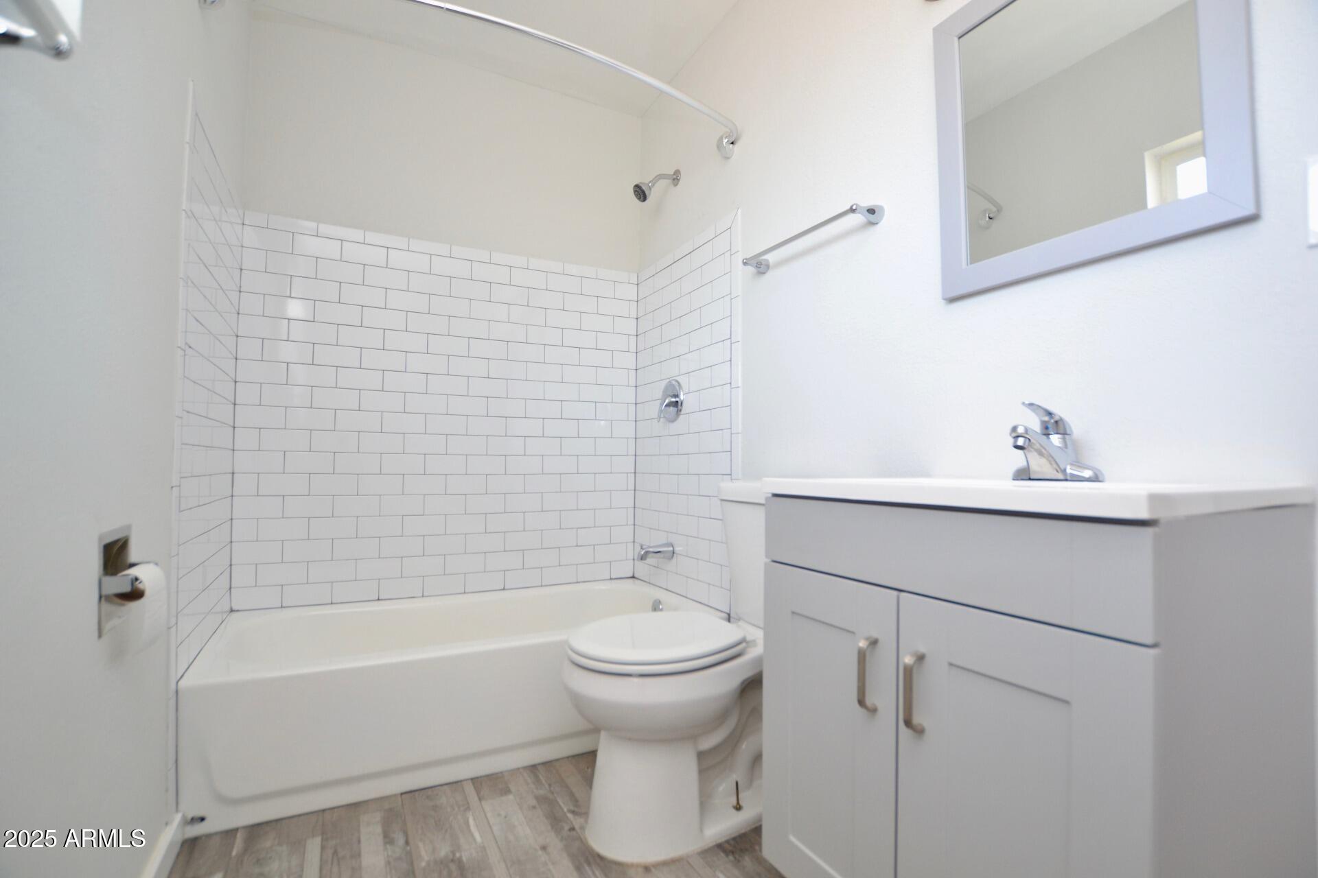 44 East Roanoke Avenue, Unit 8 Phoenix, AZ 85012 - Photo 9 of 11 a bathroom with a bathtub shower sink vanity and toilet