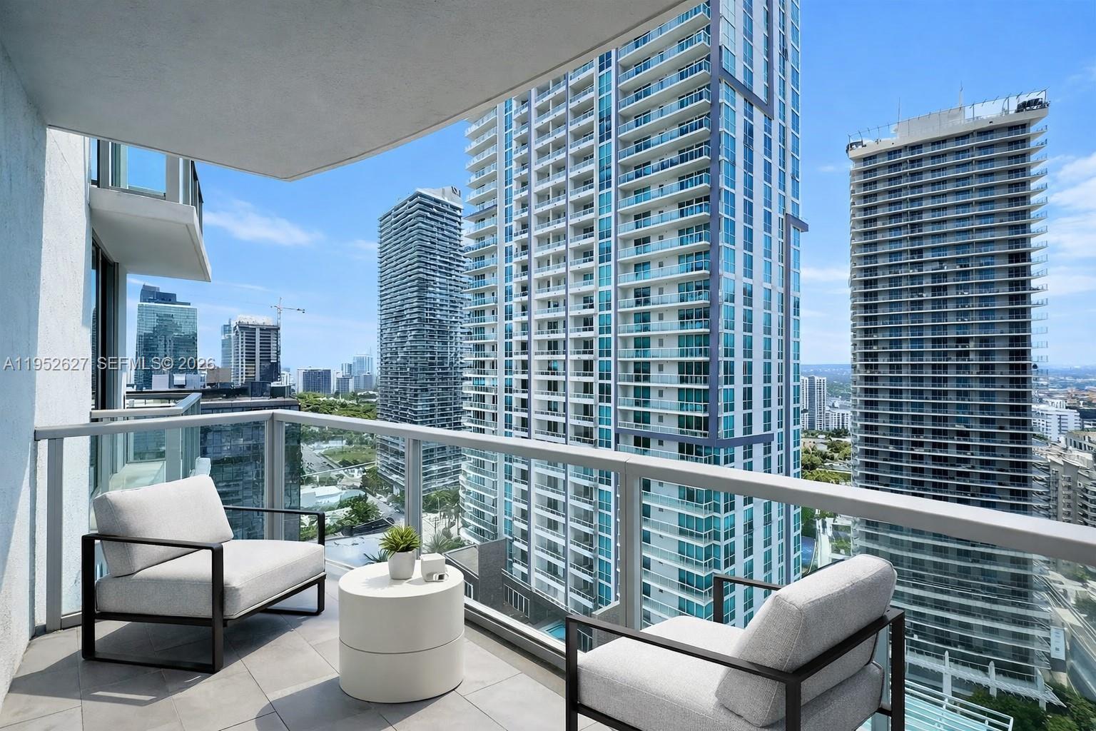 1060 Brickell Avenue, Unit 2013 Miami, FL 33131 - Photo 2 of 9 a view of a balcony with two chairs and a potted plant