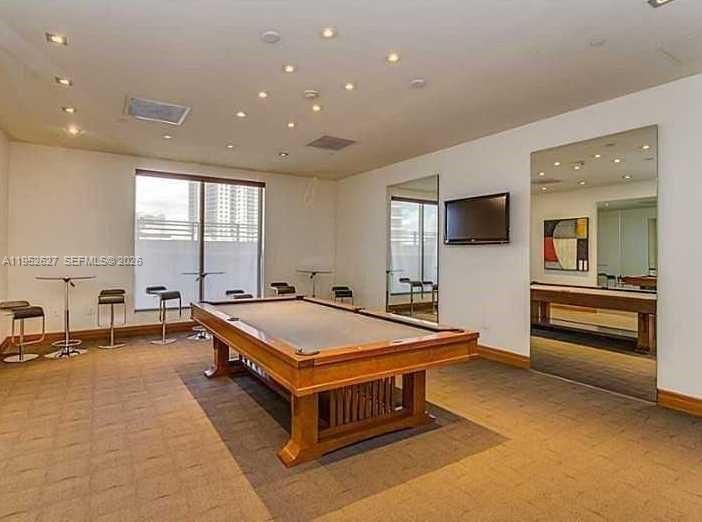 1060 Brickell Avenue, Unit 2013 Miami, FL 33131 - Photo 9 of 9 a living room with a flat screen tv and windows