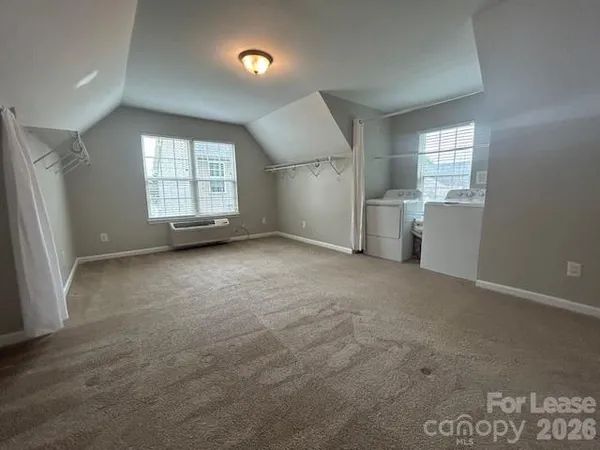 a view of a kitchen with refrigerator and white cabinets