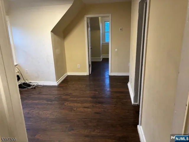 a view of a hallway with wooden floor and closet