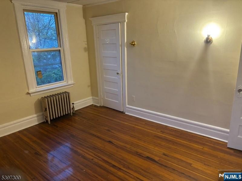 100 Harrison Place Irvington, NJ 07111 - Photo 3 of 17 a view of an empty room with wooden floor and a window