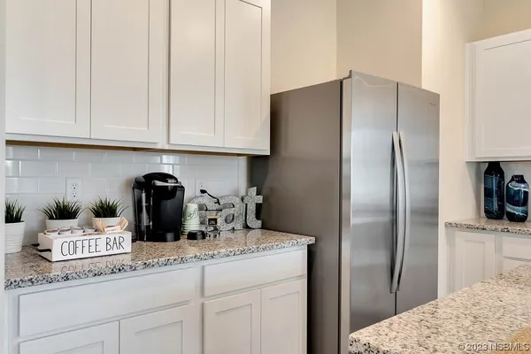 a kitchen with granite countertop white cabinets and stainless steel appliances