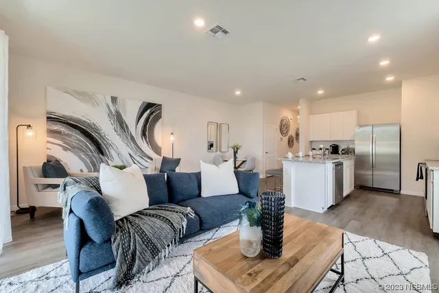 a living room with furniture kitchen view and a table