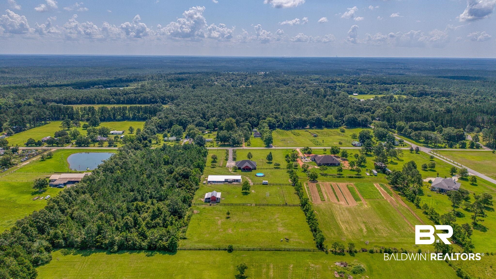 26895 C R Watson Road Robertsdale, AL 36567 - Photo 82 of 89 Expansive land parcel featuring open fields, wooded areas, and a private pond