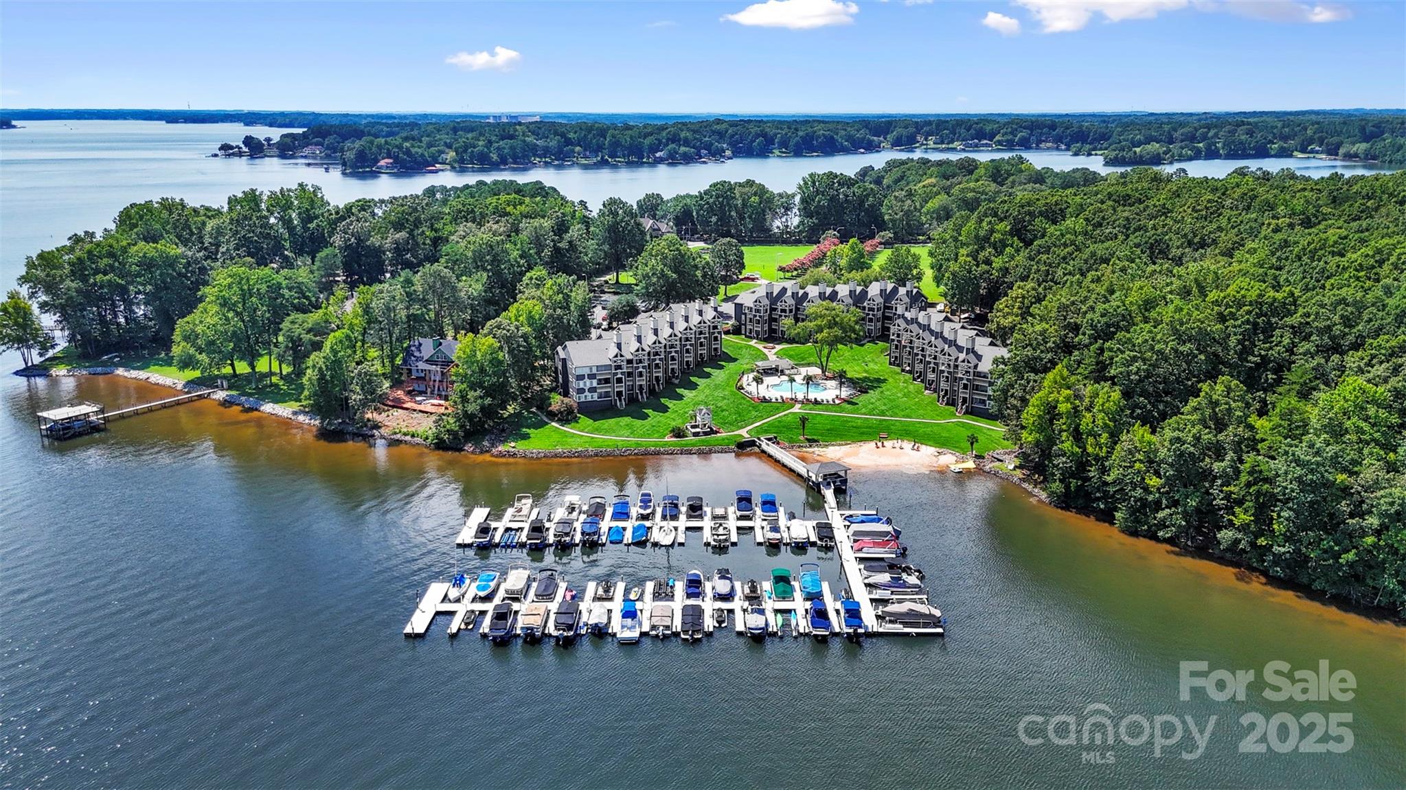 an aerial view of a house with a garden and lake view