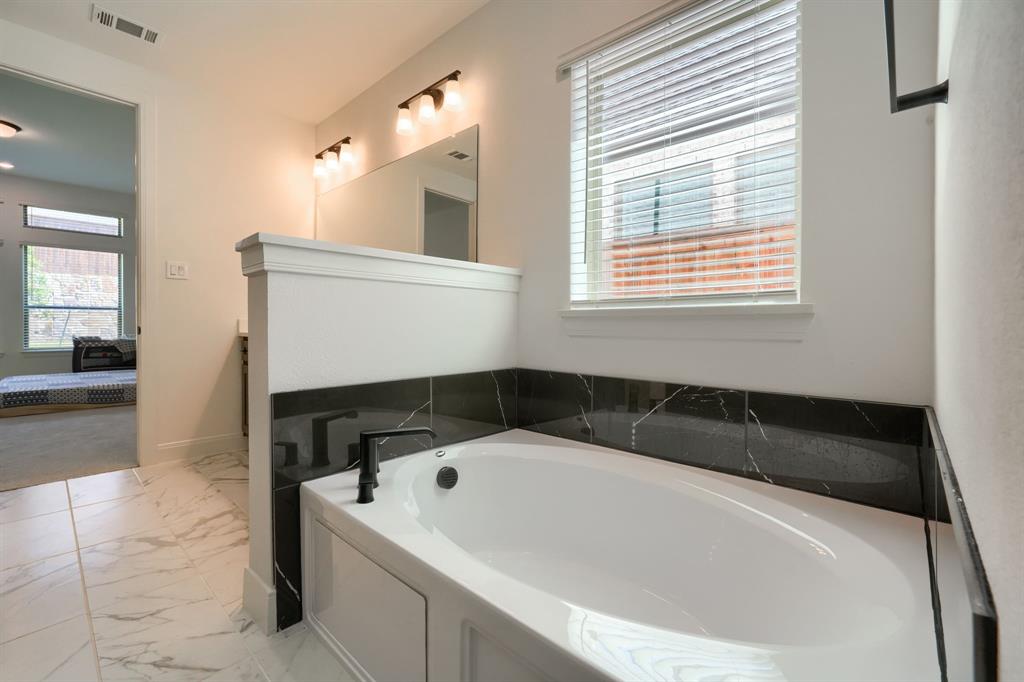1348 Bay Laurel Road Fate, TX 75087 - Photo 19 of 35 a bathroom with a bathtub and a window