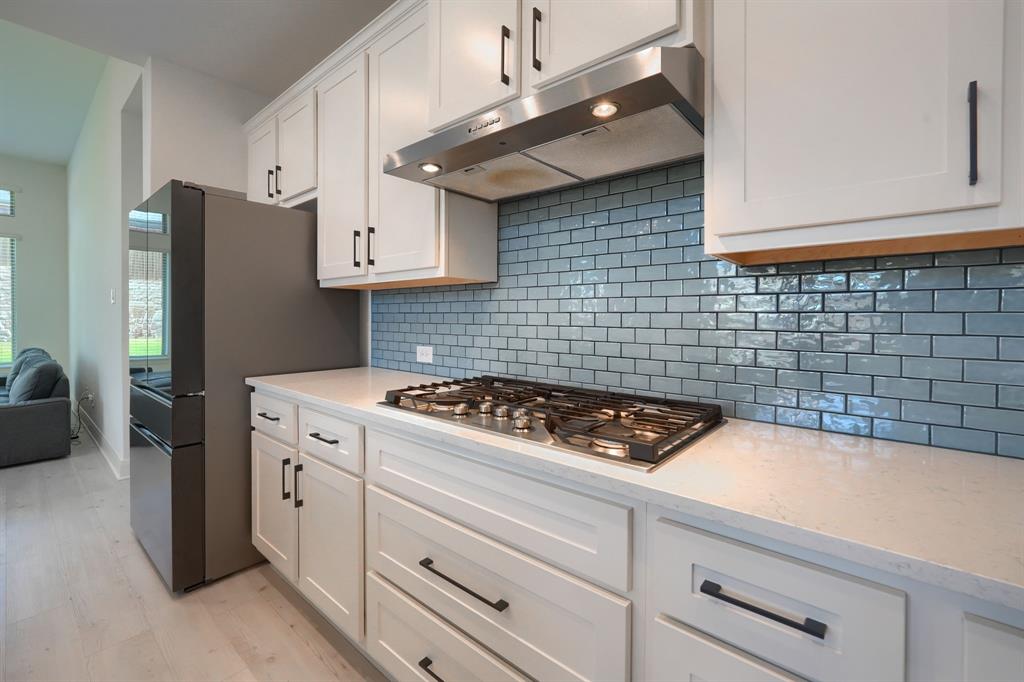 1348 Bay Laurel Road Fate, TX 75087 - Photo 9 of 35 a kitchen with cabinets a stove and a refrigerator