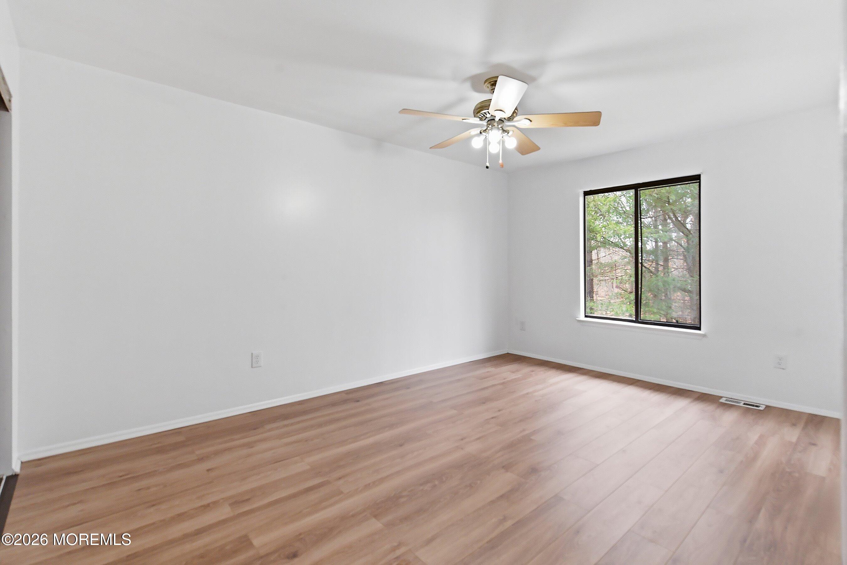 11 Owl Road Howell, NJ 07731 - Photo 22 of 48 an empty room with wooden floor fan and windows