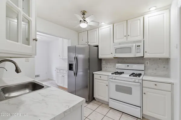 a kitchen with white cabinets and stainless steel appliances