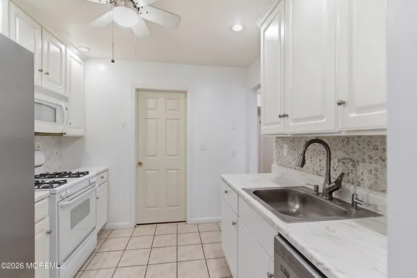 a kitchen with granite countertop a sink stove and cabinets