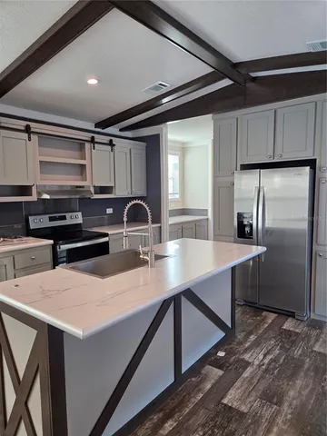 a kitchen with stainless steel appliances a sink a microwave a stove and refrigerator