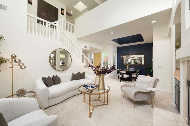 a living room with furniture a mirror and a clock