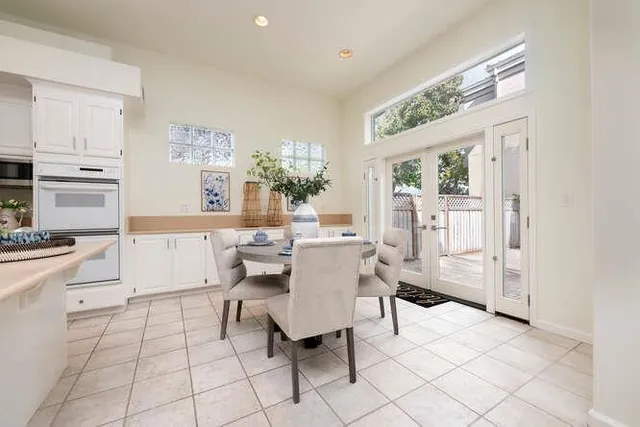 a living room with furniture a dining table and a refrigerator