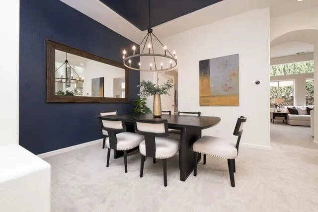 a view of a dining room with furniture a chandelier and window