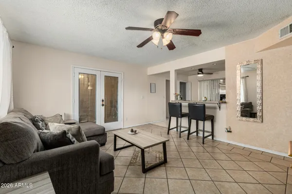 a living room with furniture and a view of kitchen