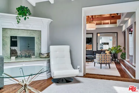 a kitchen with stainless steel appliances granite countertop a dining table chairs and refrigerator