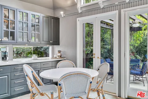 a living room with furniture a large window and gym equipment