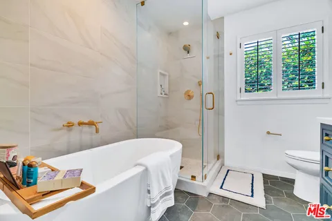 a view of a house with a yard potted plants and a large tree