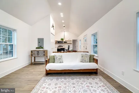 a white bed sitting in a bedroom next to a window