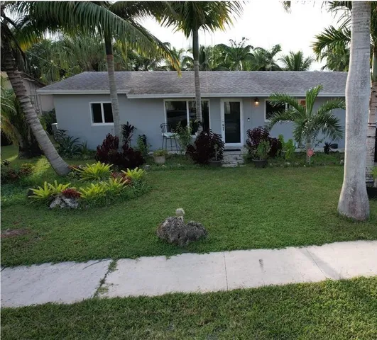 a front view of a house with a garden and plants
