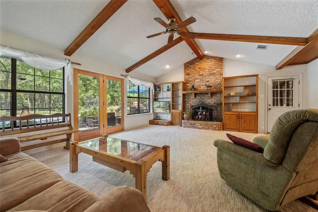 a living room with fireplace furniture and a large window