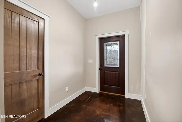 a view of empty room with wooden floor and window