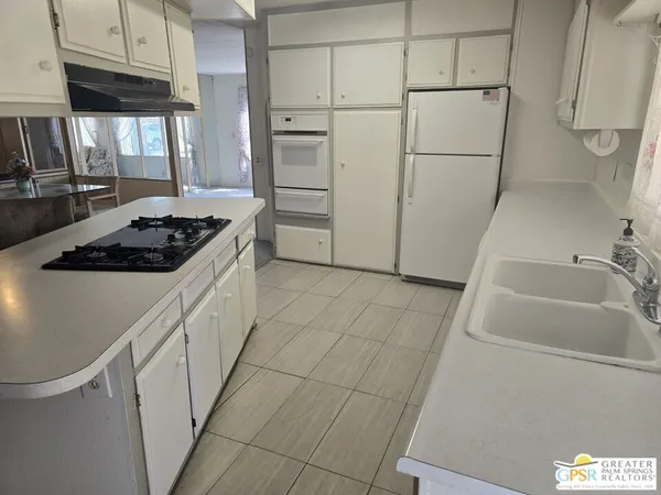 a kitchen with white cabinets and white appliances